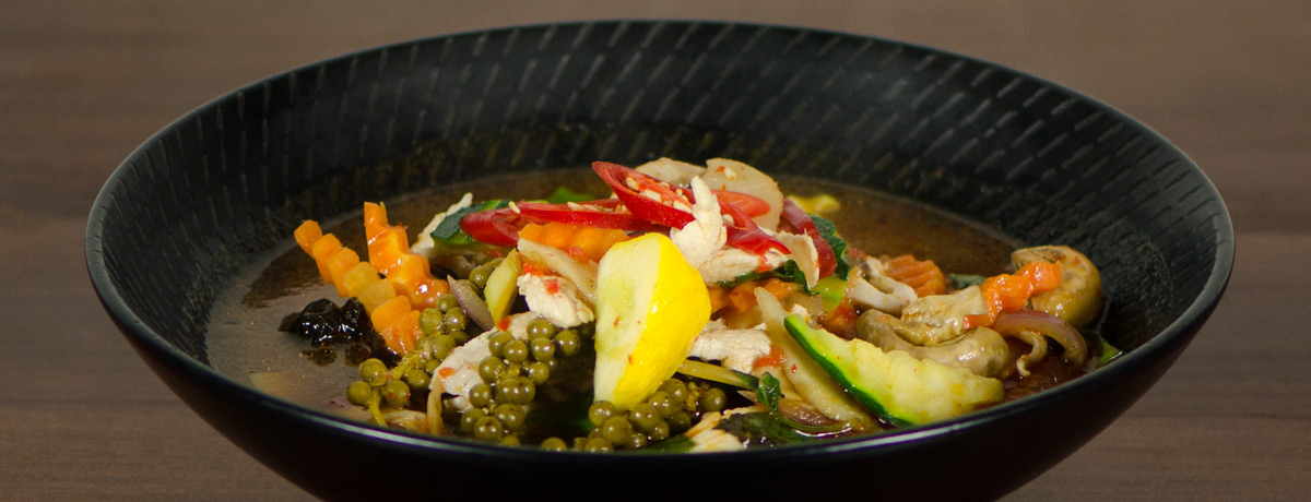 colourful thai beef and vegetable curry garnished with chilli, lemon and peppercorns