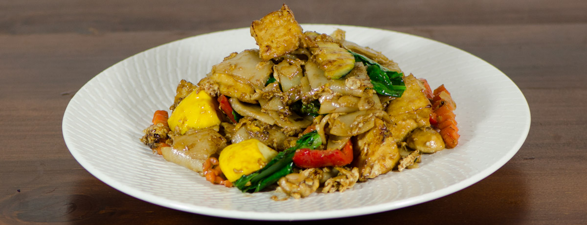 Stir fried wide flat noodle with black soy sauce, basil, fresh chilli and vegetables