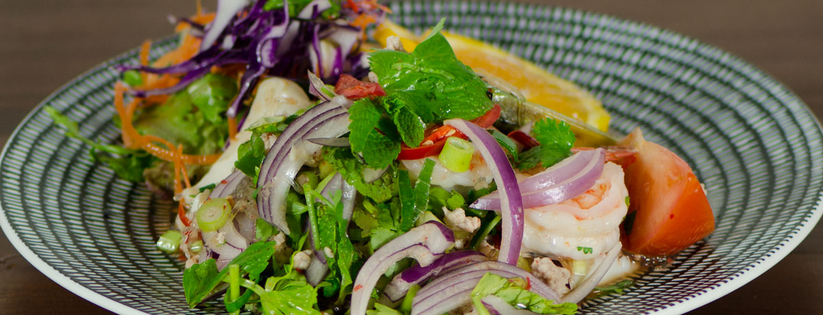 YUM GOONG (King Prawns) Thai Salad tossed with red onion, shallots, lemon grass, cucumber, tomato, mint, coriander and spicy dressing