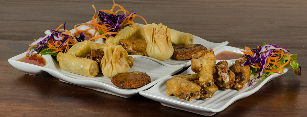 Mixed entree plate with curry puffs, spring rolls, money bags, fish cakes and chicken wings